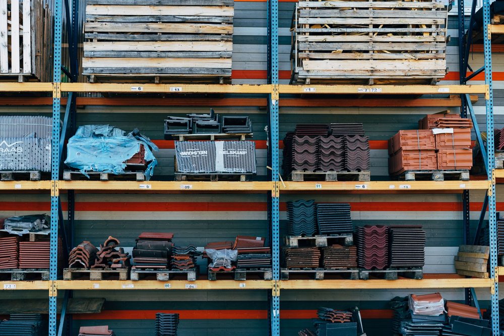 Zorganizowany magazyn materiałów budowlanych z produktami ułożonymi na regałach